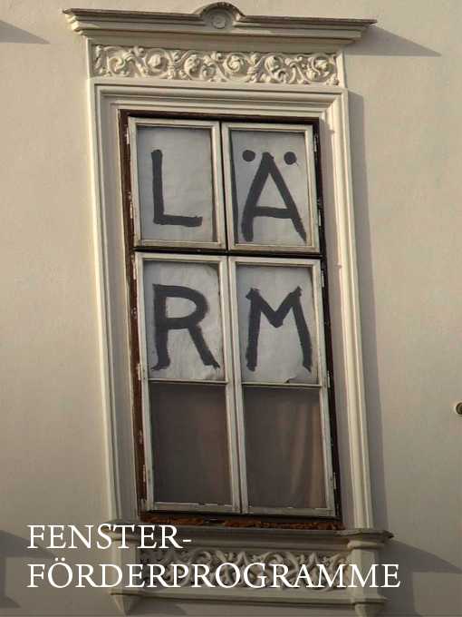 Bild eines Altbau-Fensters mit den großen, innen aufgeklebten Lettern "LÄRM"